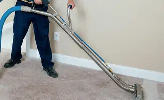 Professional operating a liquid removal machine on a carpeted floor in Baltimore, MD